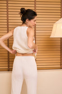 Back view of model wearing tapered pant in white swan paired with ribbed tank against wall