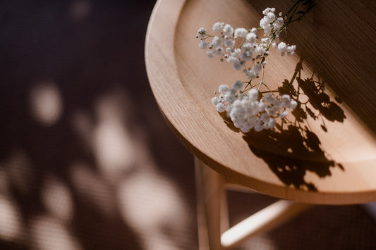 White Flowers Casting a Shadow on Wooden Side Table