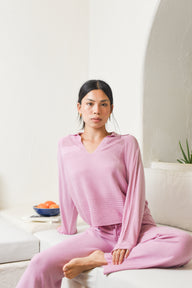 Model wearing pink knit polo pullover with matching pants