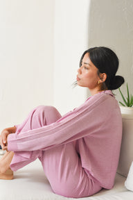 Side view of Model wearing pink knit polo pullover with matching pants