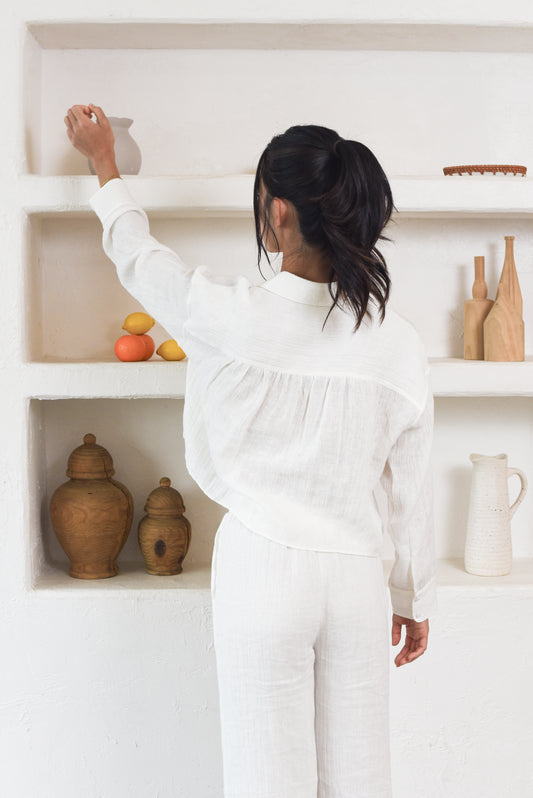 Back shot of model wearing crinkle white cropped shirt with pleated detail