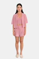 Model wearing cropped shirt in Sheer Pink  with matching tank and shorts