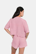 Back view of model wearing cropped shirt in Sheer Pink with matching shorts