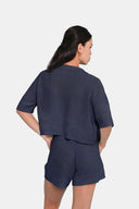 Back view of model wearing cropped shirt in Deep Navy with matching tank and shorts