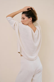 Model wearing multi-ribbed pullover in white swan back shot