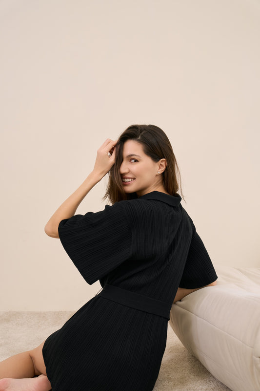 Model wearing multi-ribbed romper in black back shot